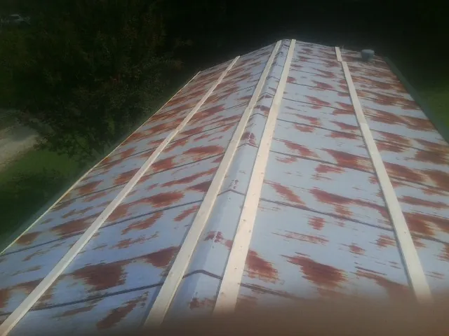 Rusted metal roof panels with new wood purlins before replacement — Storm Damage Roof Repair in Weidman by Roofing Brothers