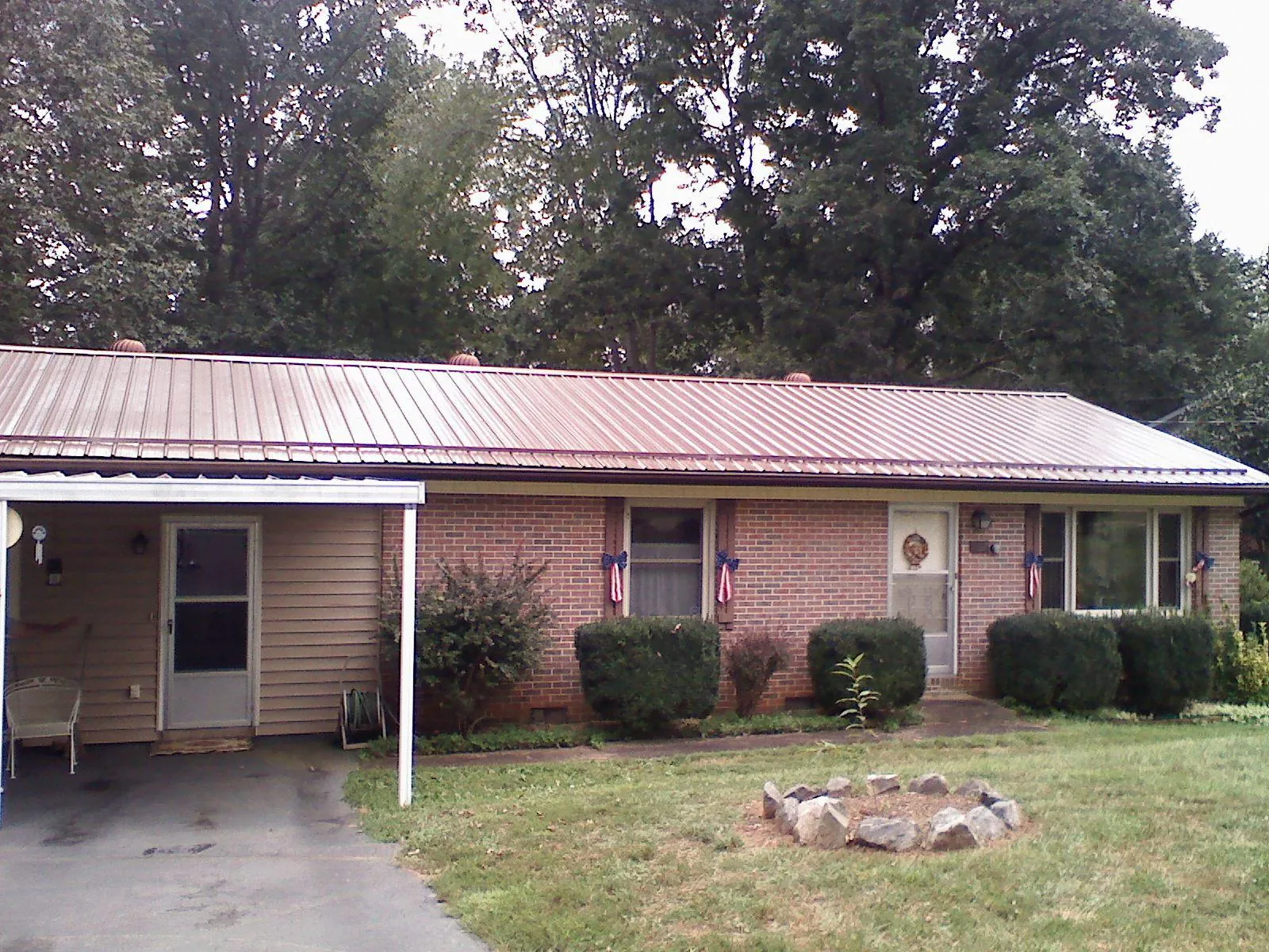 Bronze metal roof and carport on a brick ranch home — Roof Repair work by our crew in Weidman